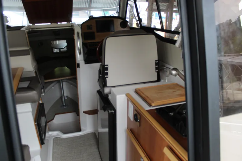 Slide: The Image of Interior view of 2024 Cutwater C-248 Coupe, featuring compact kitchen and seating area. - 8