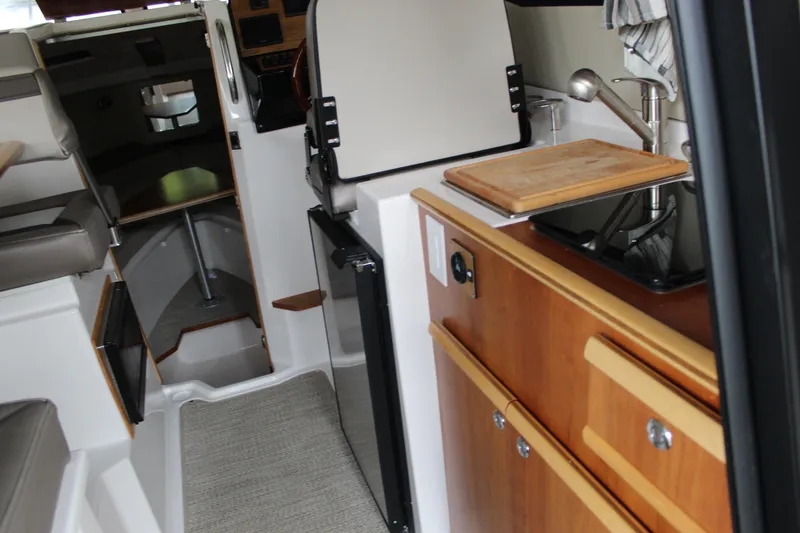 Slide: The Image of 2024 Cutwater C-248 Coupe interior with kitchenette and seating area. - 9