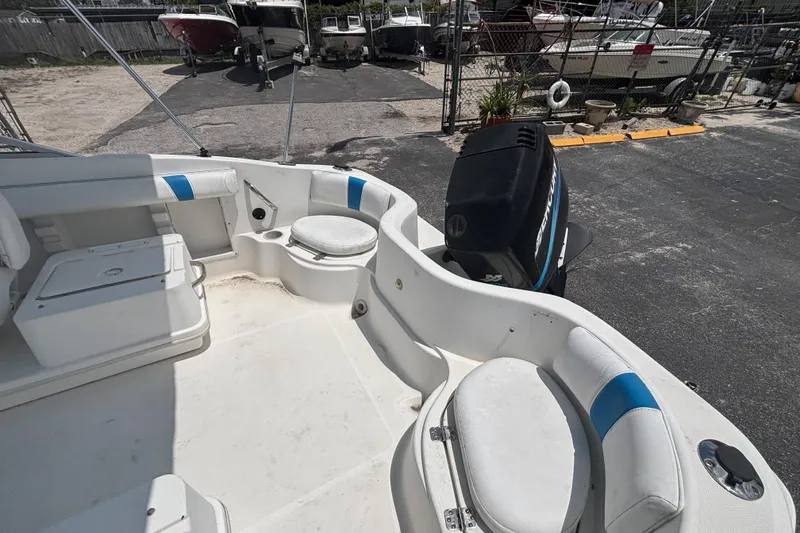 Slide: The Image of 2002 Wellcraft 180 Sportsman boat interior with seating and outboard motor in a marina. - 10