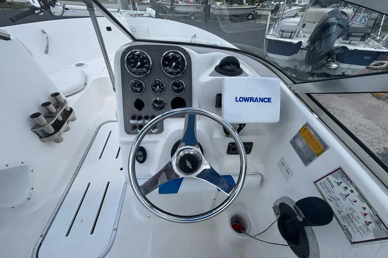 Slide: The Image of 2002 Wellcraft 180 Sportsman boat dashboard with steering wheel and Lowrance navigation system. - 13
