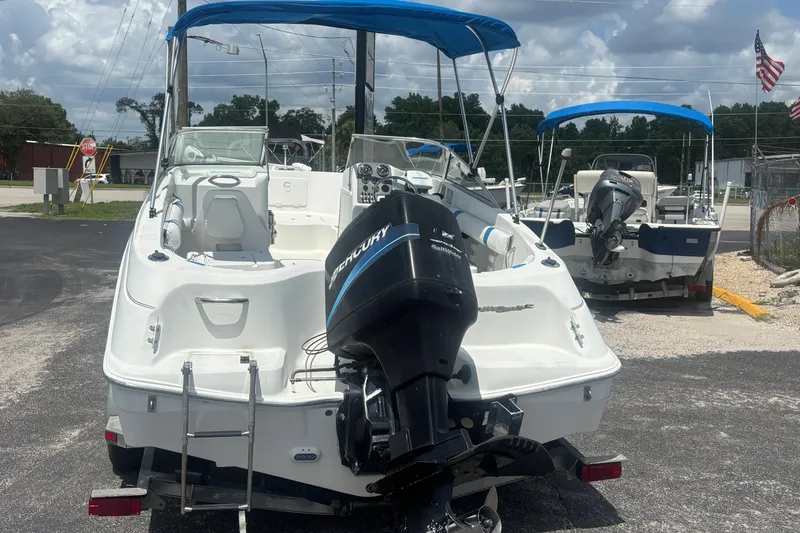 Slide: The Image of 2002 Wellcraft 180 Sportsman boat with Mercury outboard motor, parked outdoors under blue skies. - 3