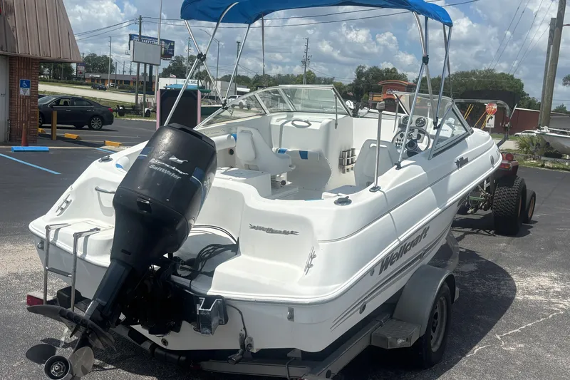 Slide: The Image of 2002 Wellcraft 180 Sportsman boat with outboard motor on trailer in parking lot. - 4