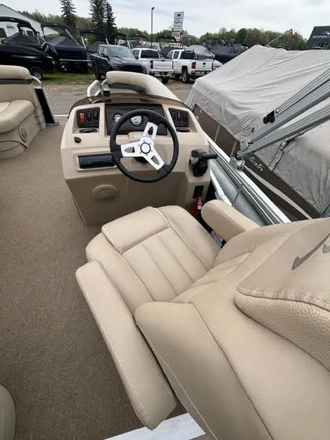 Slide: The Image of Interior of a 2013 Bennington 20SLMX pontoon boat with beige steering wheel and seats. - 8