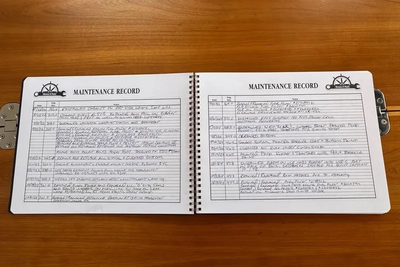 Slide: The Image of Open maintenance record book for 2020 Cutwater C-30 CB boat on wooden table. - 10