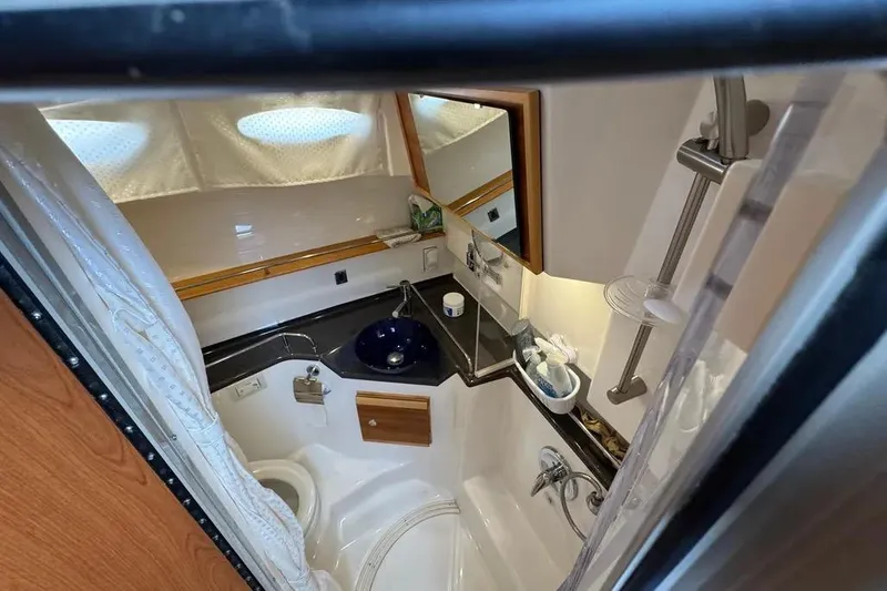 Slide: The Image of Compact bathroom in a 2020 Cutwater C-30 CB boat, featuring a sink, toilet, and shower. - 11