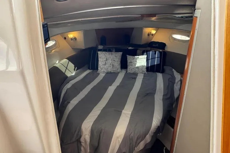 Slide: The Image of Cozy cabin interior of 2020 Cutwater C-30 CB with striped bedding and ambient lighting. - 12