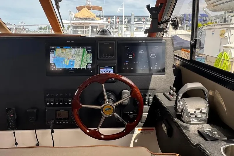 Slide: The Image of 2020 Cutwater C-30 CB helm with navigation screens and controls in a marina setting. - 15