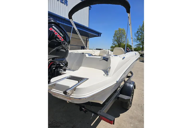 Slide: The Image of 2023 Stingray 182 SC boat with Mercury engine, parked outdoors on a sunny day. - 11