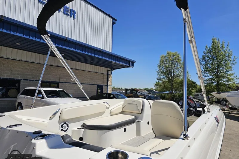Slide: The Image of 2023 Stingray 182 SC boat with seating, parked outdoors under clear blue sky. - 13