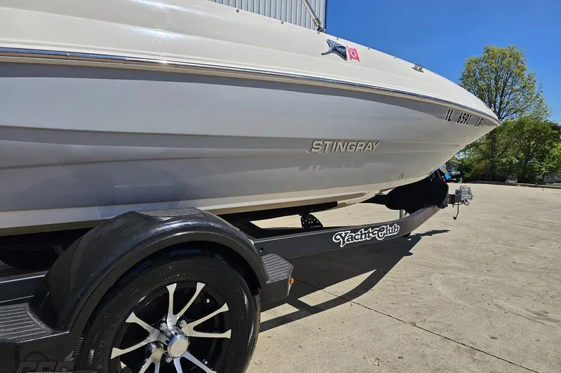 Slide: The Image of 2023 Stingray 182 SC boat on trailer, parked outdoors under clear blue sky. - 14