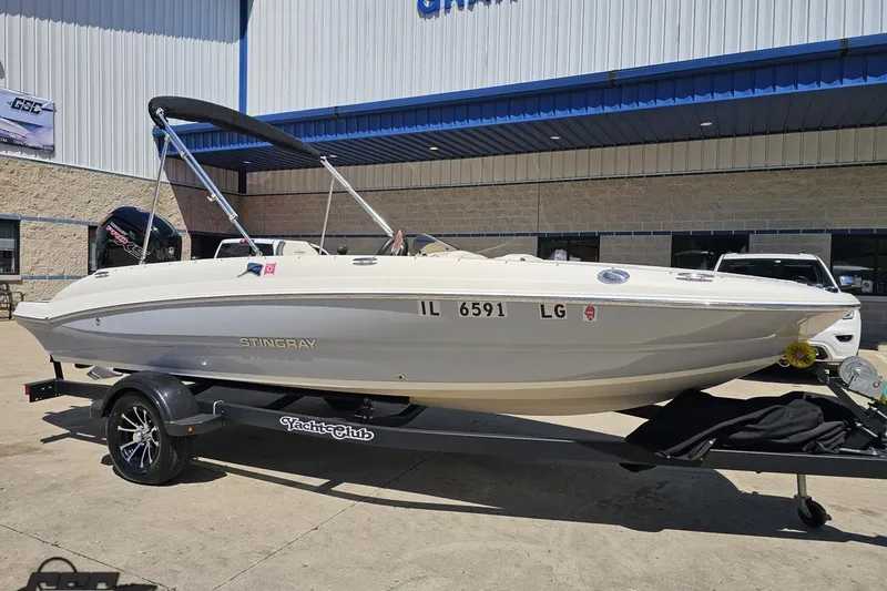 Slide: The Image of 2023 Stingray 182 SC boat on trailer outside a building, sunny day. - 16