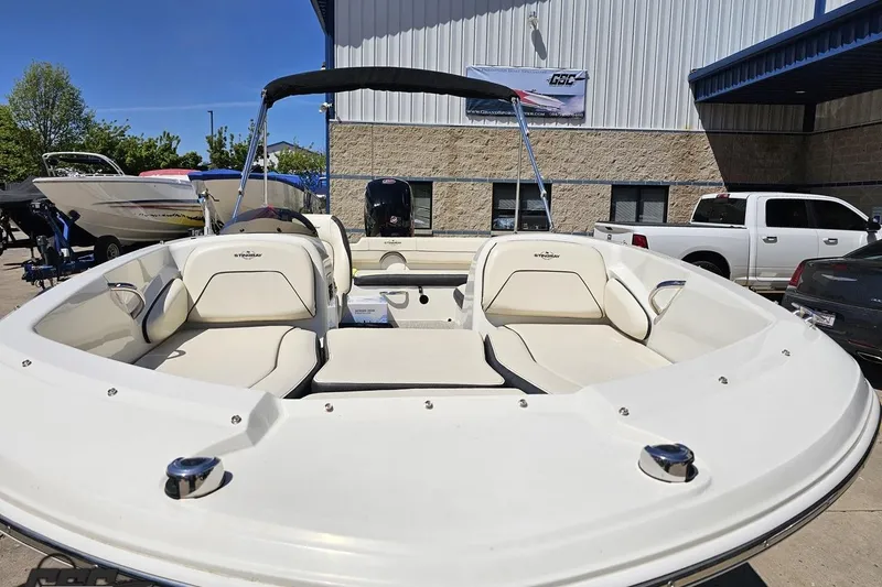 Slide: The Image of 2023 Stingray 182 SC boat with spacious seating, displayed outdoors near a building. - 18