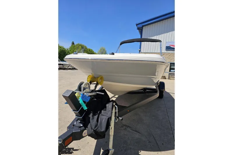 Slide: The Image of 2023 Stingray 182 SC boat on trailer, parked outdoors under clear blue sky. - 20
