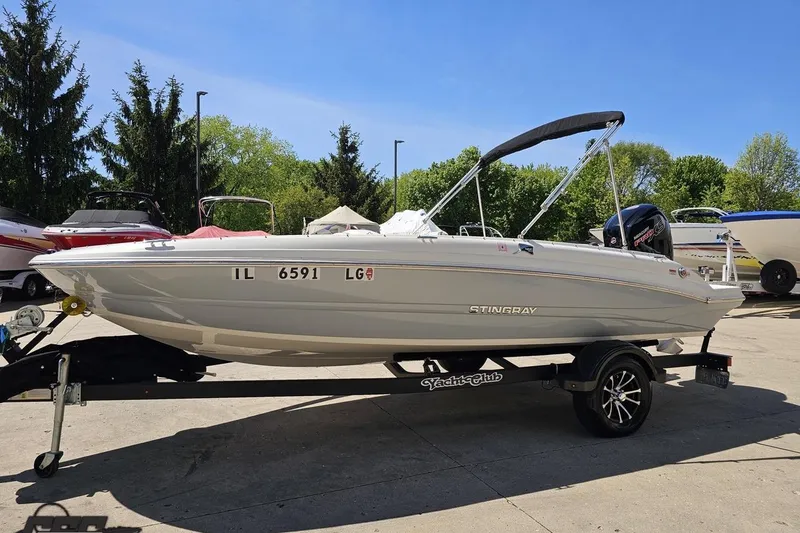 Slide: The Image of 2023 Stingray 182 SC boat on trailer, parked outdoors under clear sky. - 22