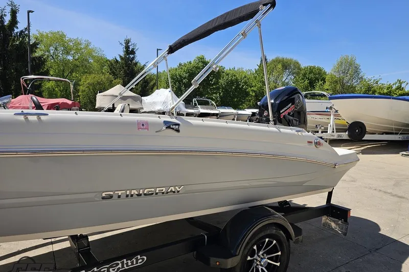 Slide: The Image of 2023 Stingray 182 SC boat on trailer, featuring sleek design and outboard motor. - 24