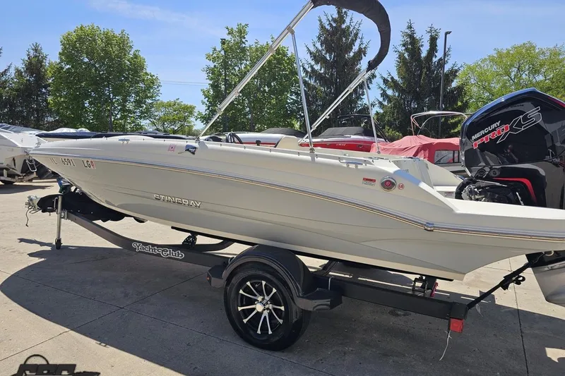 Slide: The Image of 2023 Stingray 182 SC boat on trailer with Mercury Pro XS engine, parked outdoors. - 26