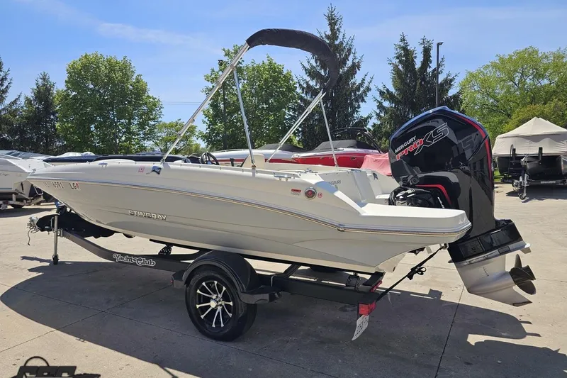 Slide: The Image of 2023 Stingray 182 SC boat on trailer with Mercury Pro XS engine, parked outdoors. - 27