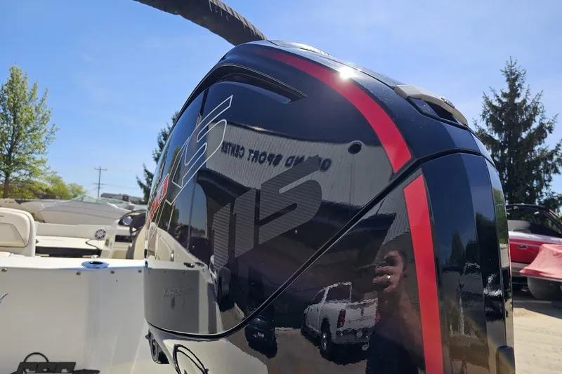Slide: The Image of 2023 Stingray 182 SC boat with sleek black and red motor, outdoor display. - 31