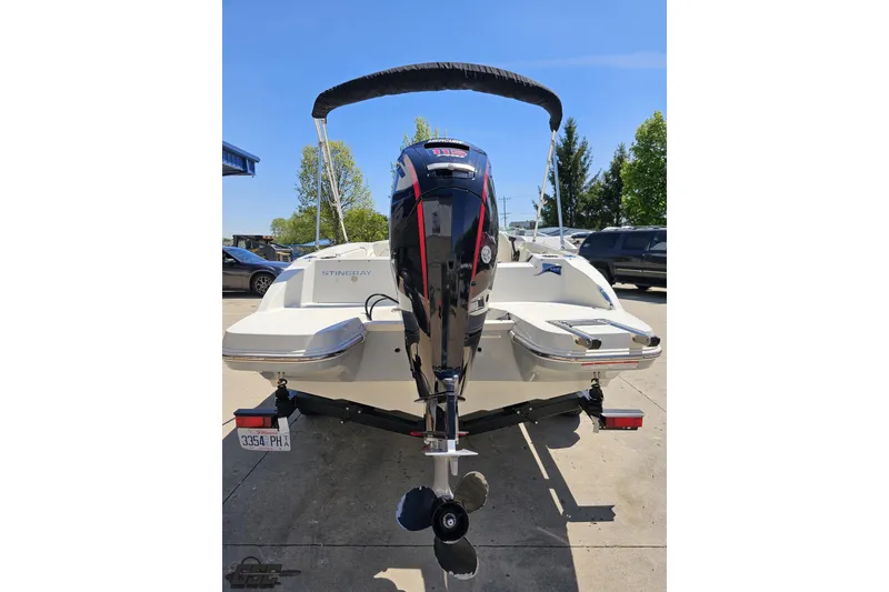 Slide: The Image of 2023 Stingray 182 SC boat with outboard motor, parked outdoors on a sunny day. - 32