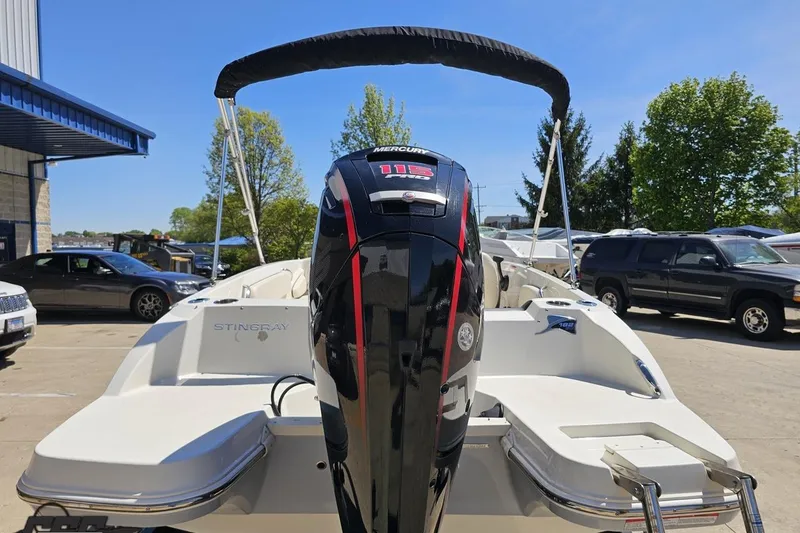 Slide: The Image of 2023 Stingray 182 SC boat with Mercury engine, parked outdoors under clear blue sky. - 33