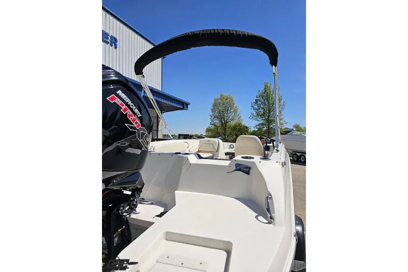 Slide: The Image of 2023 Stingray 182 SC boat with Mercury Pro XS engine, docked outdoors under clear blue sky. - 34