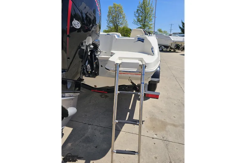 Slide: The Image of 2023 Stingray 182 SC boat with ladder and outboard motor in a marina setting. - 35