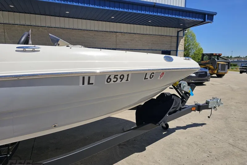 Slide: The Image of 2023 Stingray 182 SC boat on trailer, parked outside a building. - 5