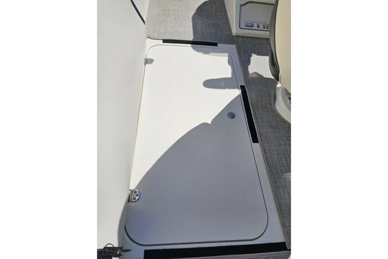Slide: The Image of 2023 Stingray 182 SC boat interior with storage compartment and textured flooring. - 50