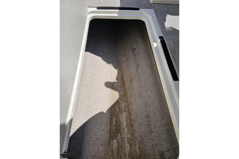 Slide: The Image of 2023 Stingray 182 SC boat storage compartment with carpeted interior. - 51