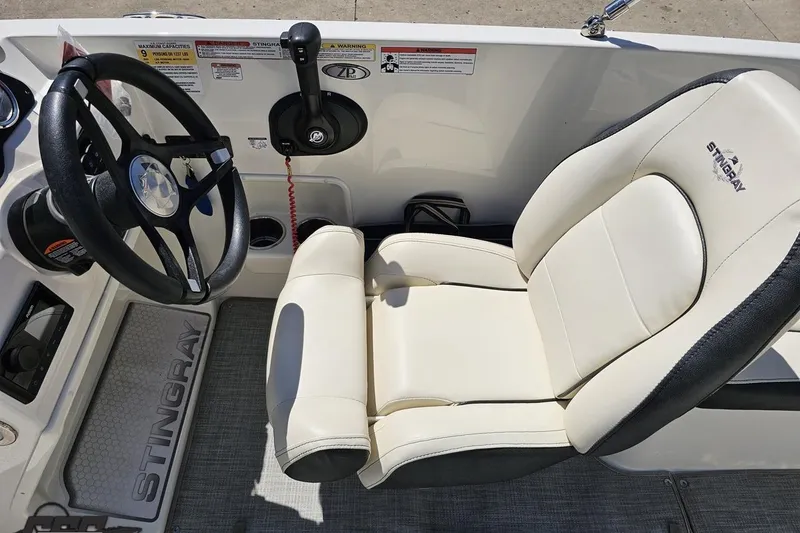 Slide: The Image of 2023 Stingray 182 SC boat interior with steering wheel and comfortable seating. - 52