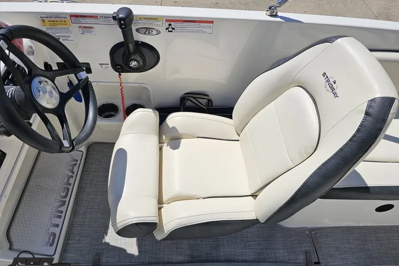 Slide: The Image of 2023 Stingray 182 SC boat interior with steering wheel and cushioned seat. - 53