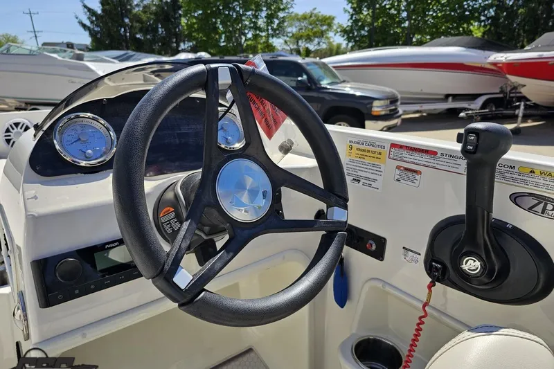 Slide: The Image of 2023 Stingray 182 SC boat dashboard with steering wheel and control panel. - 55