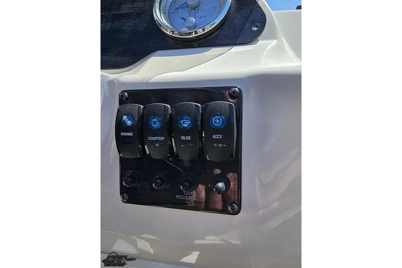 Slide: The Image of Control panel of 2023 Stingray 182 SC boat with switches for navigation, courtesy, bilge, and accessories. - 58