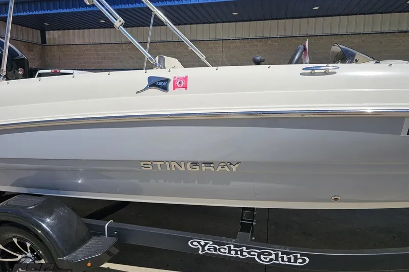 Slide: The Image of 2023 Stingray 182 SC boat on trailer, side view under blue awning. - 6