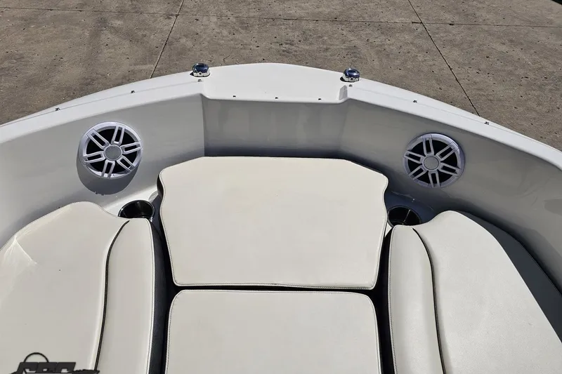 Slide: The Image of 2023 Stingray 182 SC boat interior with white cushioned seating and built-in speakers. - 64