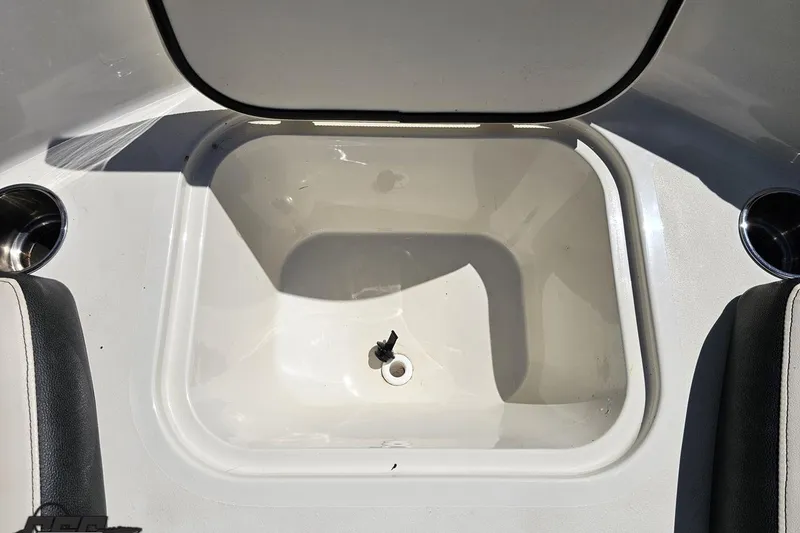 Slide: The Image of 2023 Stingray 182 SC boat storage compartment with open lid, showcasing interior space. - 74