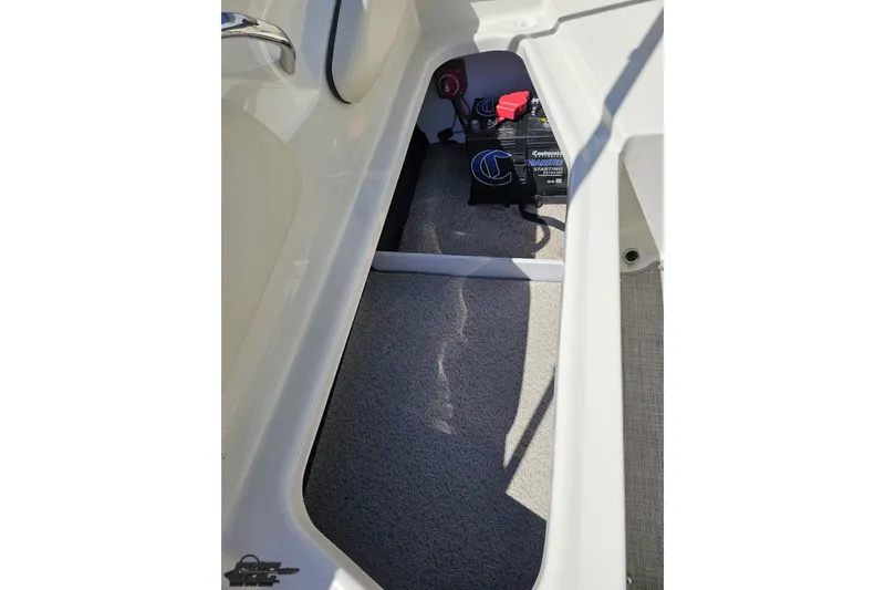 Slide: The Image of 2023 Stingray 182 SC boat interior storage compartment with marine battery. - 80