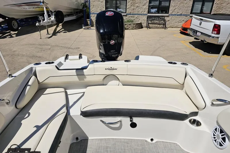 Slide: The Image of 2023 Stingray 182 SC boat interior with seating and motor, displayed outdoors. - 82