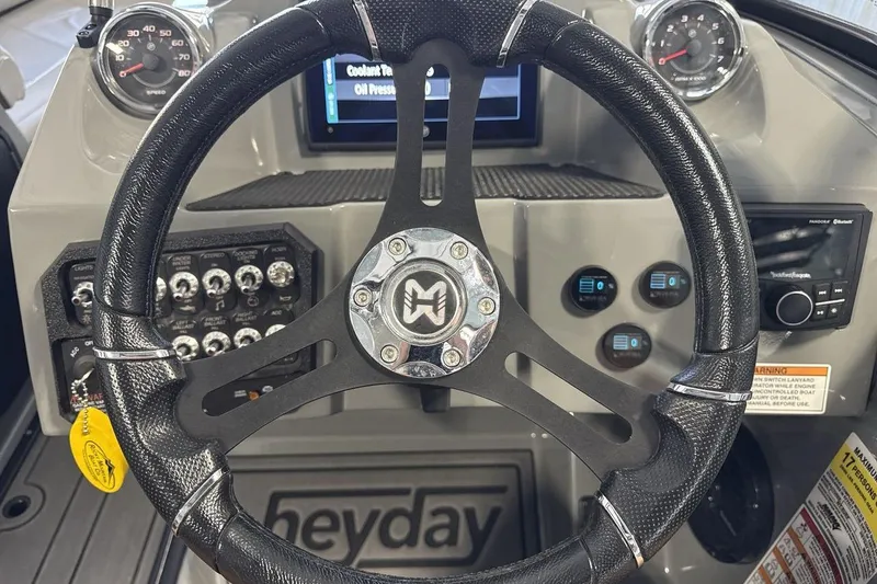 Slide: The Image of Steering wheel and dashboard of 2024 Heyday WTSurf boat with control panels. - 14