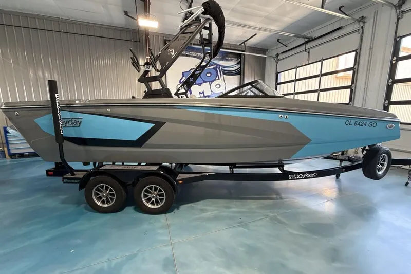 Slide: The Image of 2024 Heyday WTSurf boat in showroom, blue and gray design on trailer. - 6