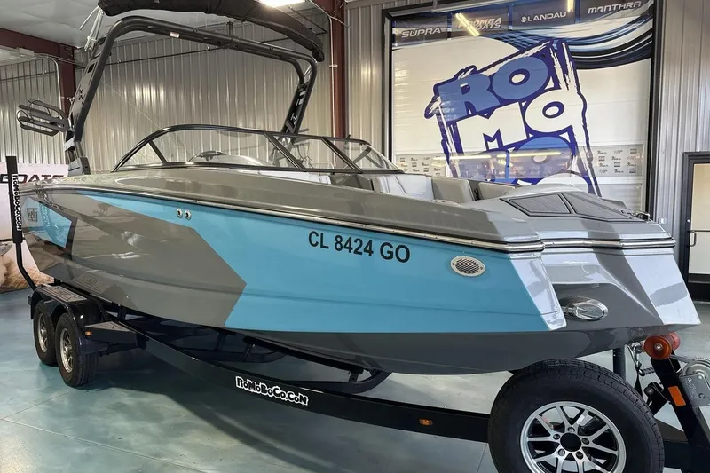 Slide: The Image of 2024 Heyday WTSurf boat in showroom, featuring sleek gray and blue design on trailer. - 7