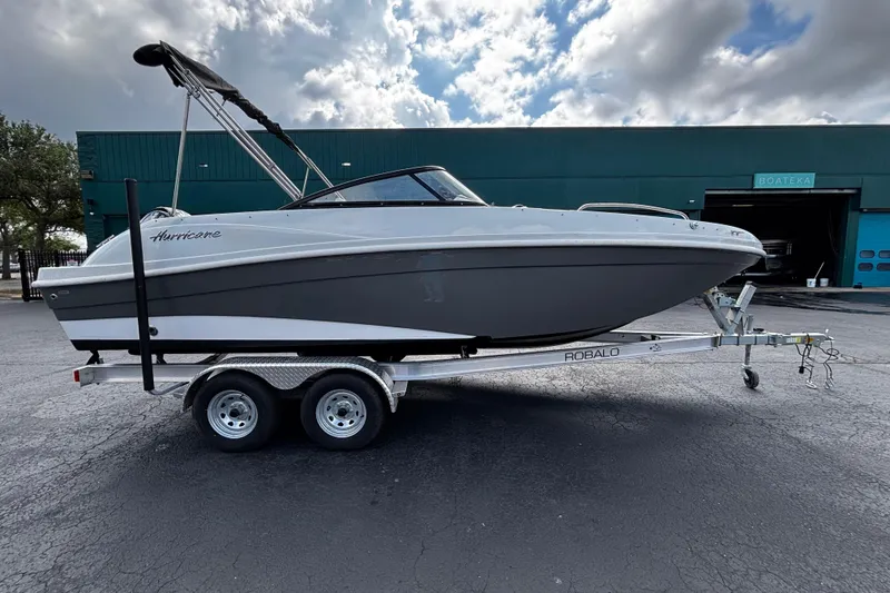 The Image of 2022 Hurricane SunDeck 217 OB boat on trailer, parked outdoors under cloudy sky. - 1