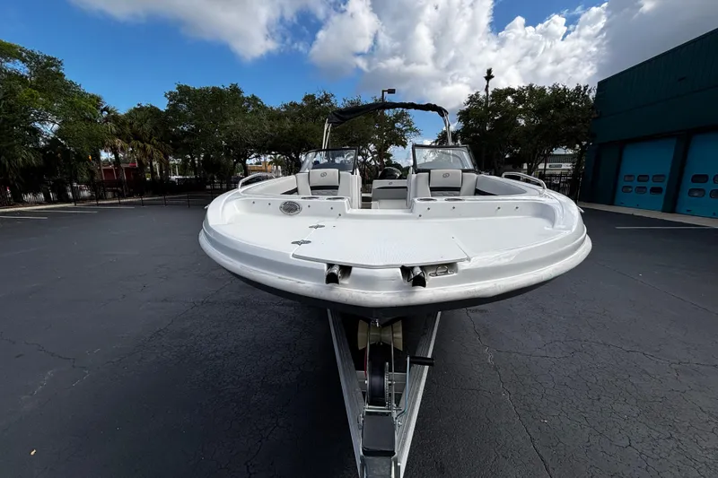 Slide: The Image of 2022 Hurricane SunDeck 217 OB boat on trailer, parked outdoors under cloudy sky. - 4