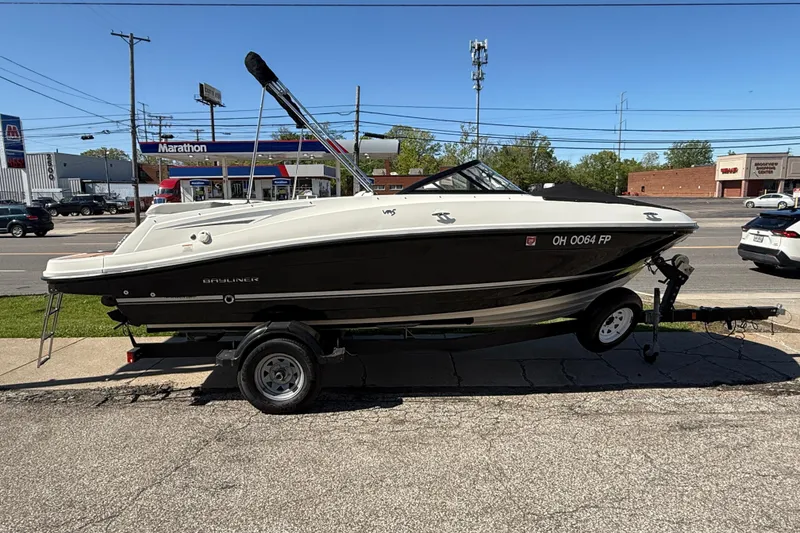 The Image of 2016 Bayliner VR5 Bowrider I/O boat on trailer, parked near a gas station. - 0