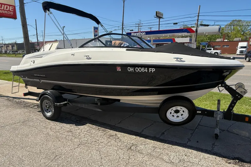 Slide: The Image of 2016 Bayliner VR5 Bowrider I/O boat on trailer, parked near a gas station. - 1