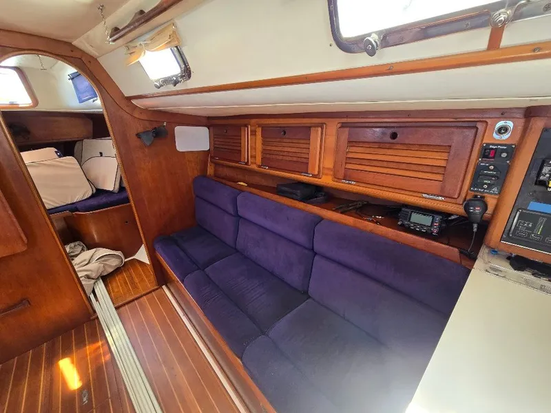 Slide: The Image of Interior of a 1995 Freedom sloop with purple sofa and wooden cabinetry. - 11