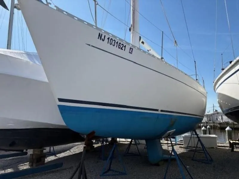 Slide: The Image of 1995 Freedom Sloop docked in harbor, white and blue paint. - 4