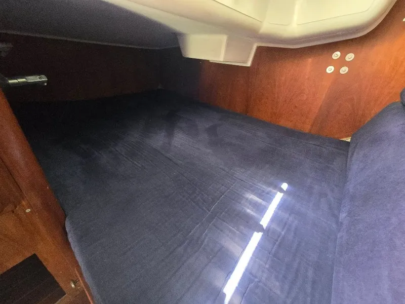 Slide: The Image of Interior of a 1995 Freedom sloop with wooden walls and blue upholstery. - 7