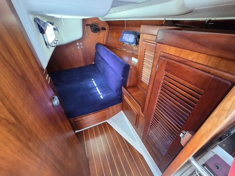 Slide: The Image of Interior of a 1995 Freedom sloop with wooden finish and blue upholstery. - 8