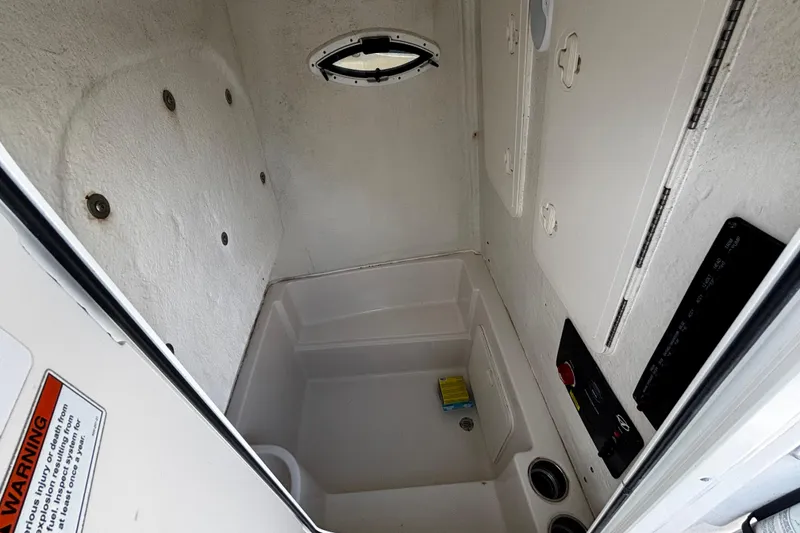 Slide: The Image of Interior of 2022 Sailfish 242 CC boat, featuring storage compartment and control panel. - 9